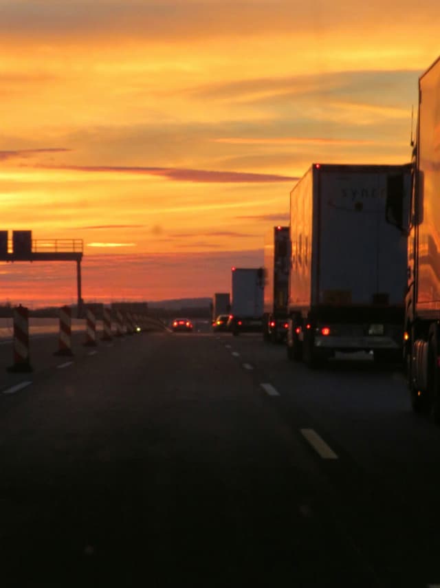 Semi trucks on a highway at sunset